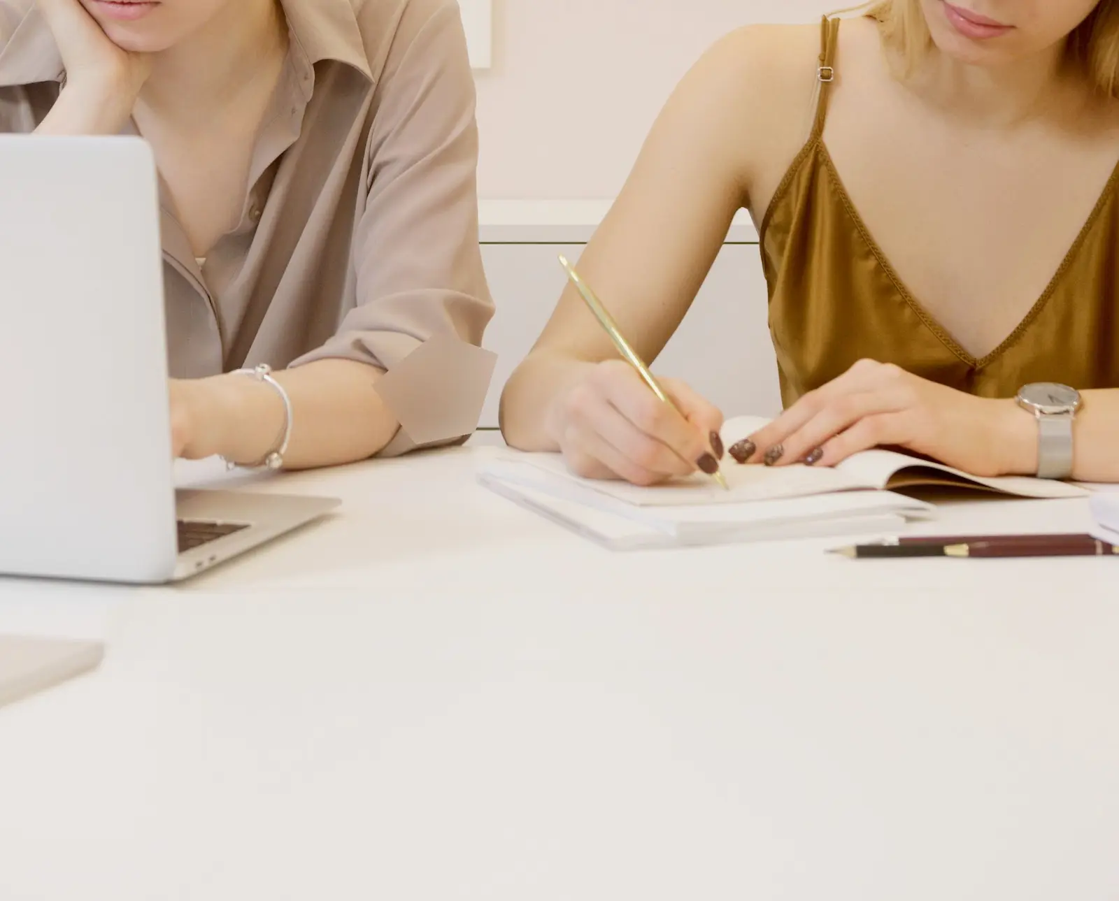Deux femmes comparent des offres sur un ordinateur portable, l'une prend des notes sur un carnet